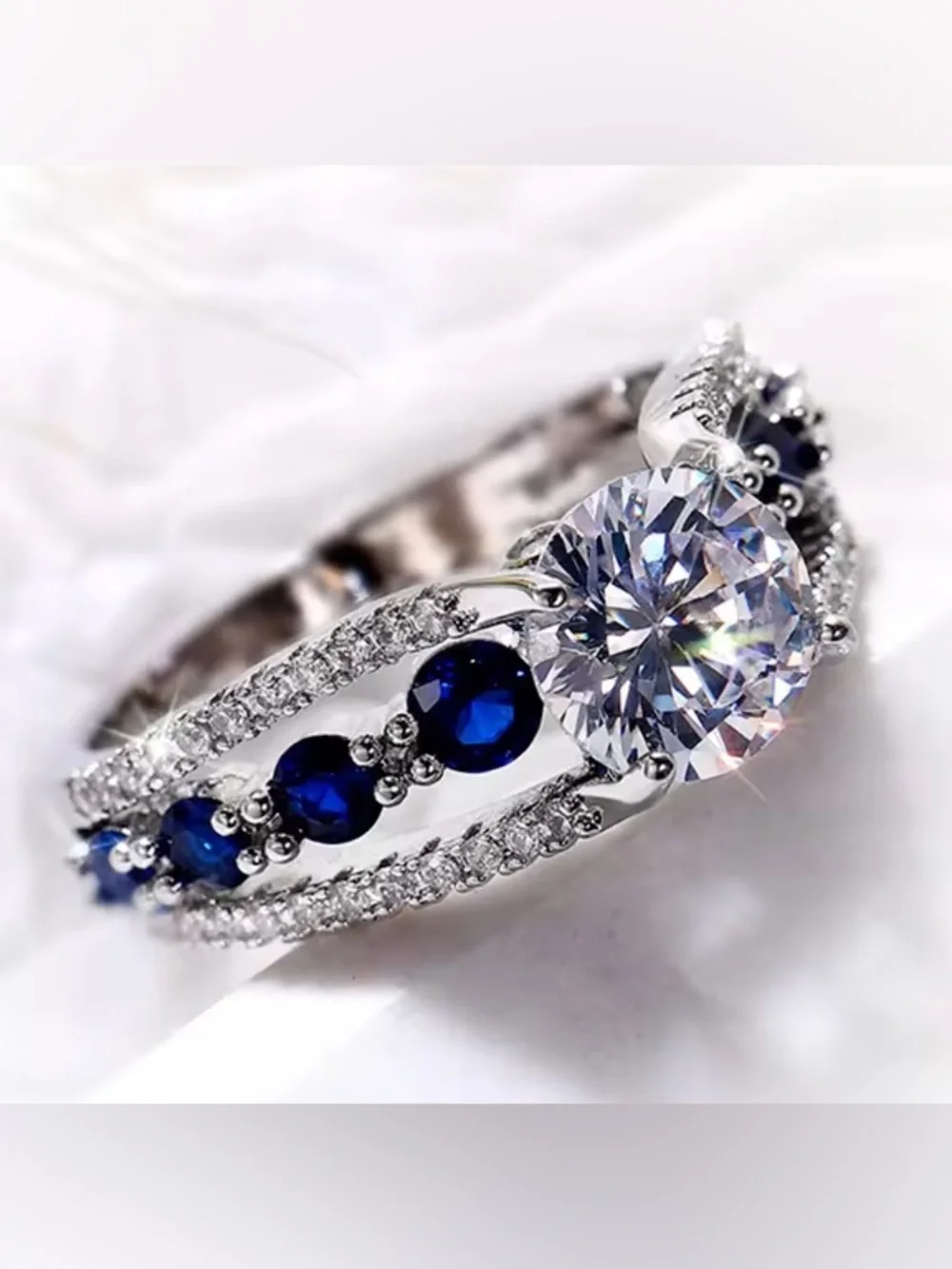 Silver Ring with Deep Blue Stones and Clear Center Gem.